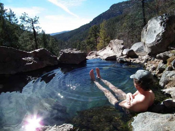 A man relaxes in Spence Hot Springs and enjoys the view.